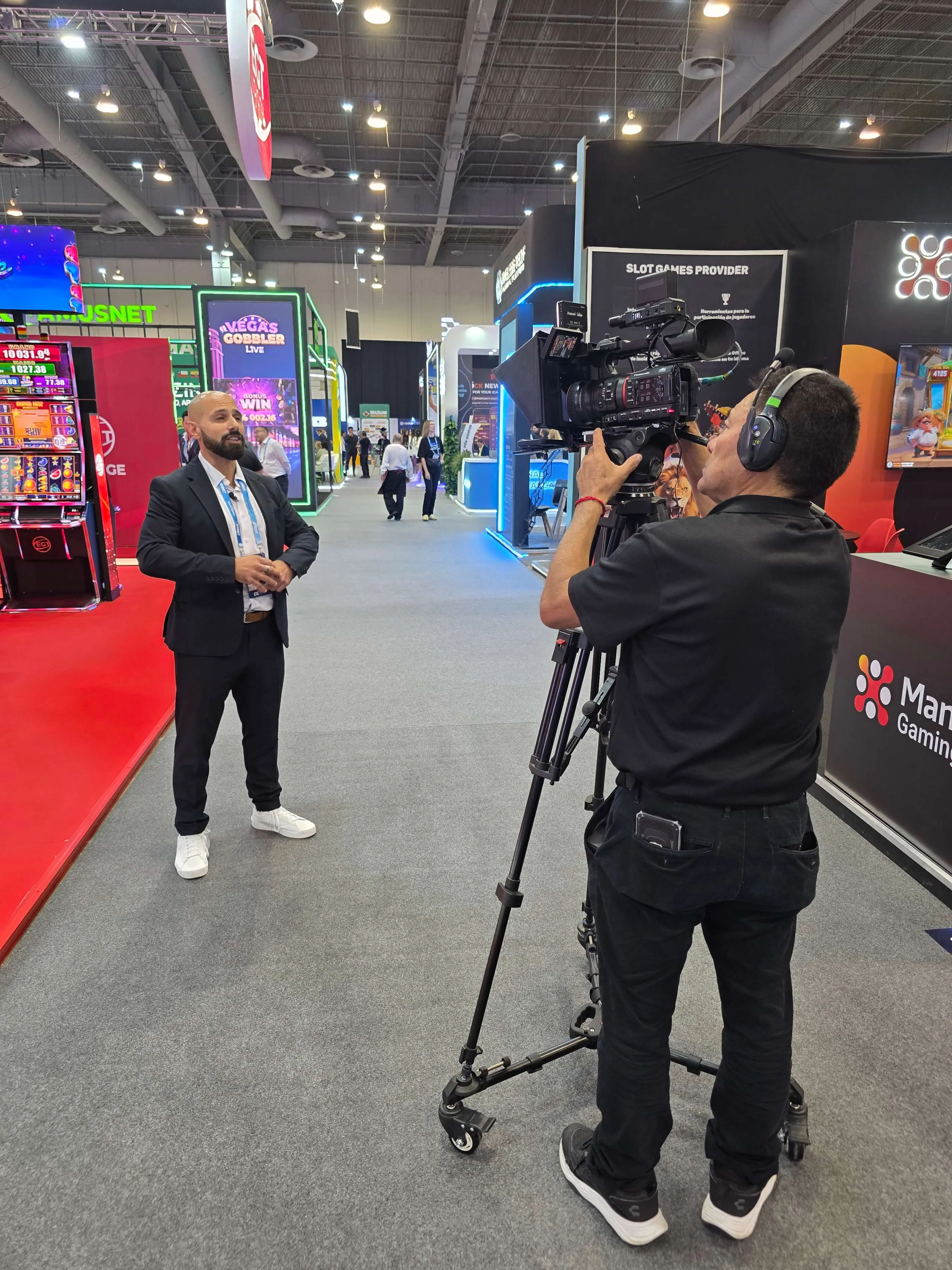 Interview set-up on the SiGMA exhibition floor in Mexico City, with a camera on a tripod and a presenter.