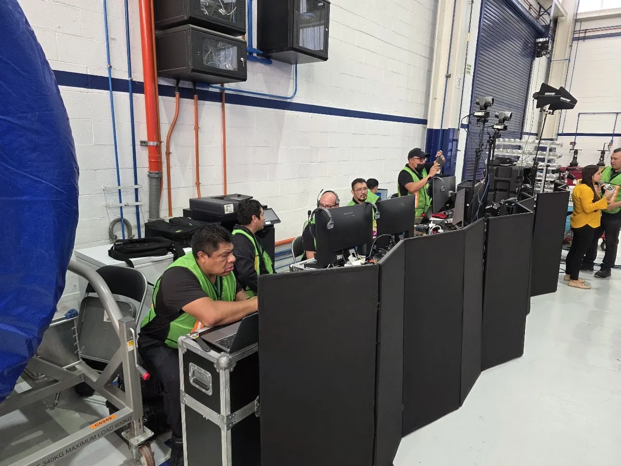 Production control area inside the ITP Aero plant in Querétaro, with crew in safety vests at the monitors.